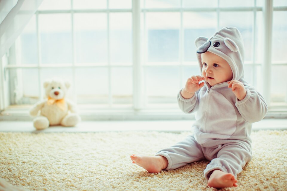 نوزاد و عروسک کنار پنجره با نور طبیعی