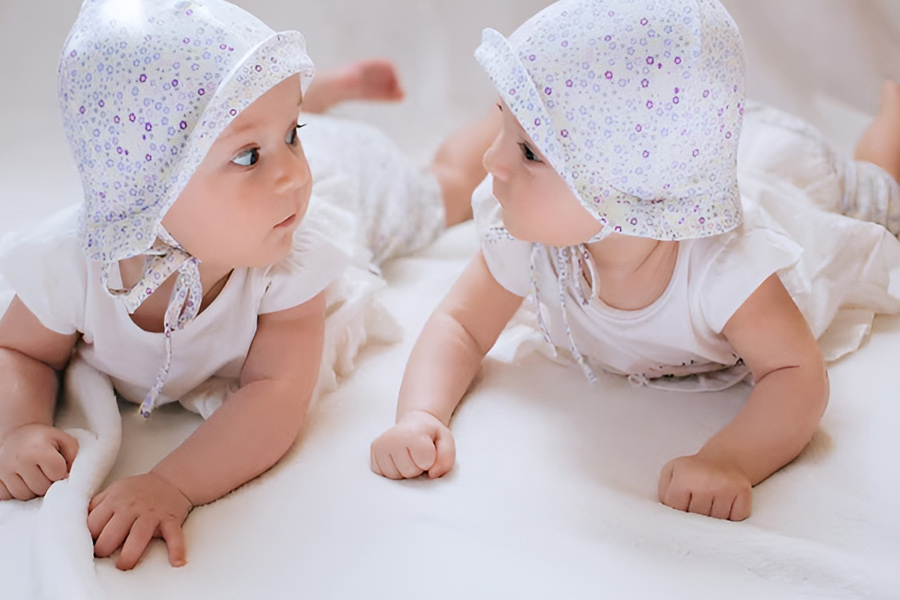 ژست عکس نوزاد دوقلو چشم در چشم با یکدیگر